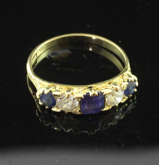 An 18ct gold, five stone sapphire and diamond set half hoop ring, size O.